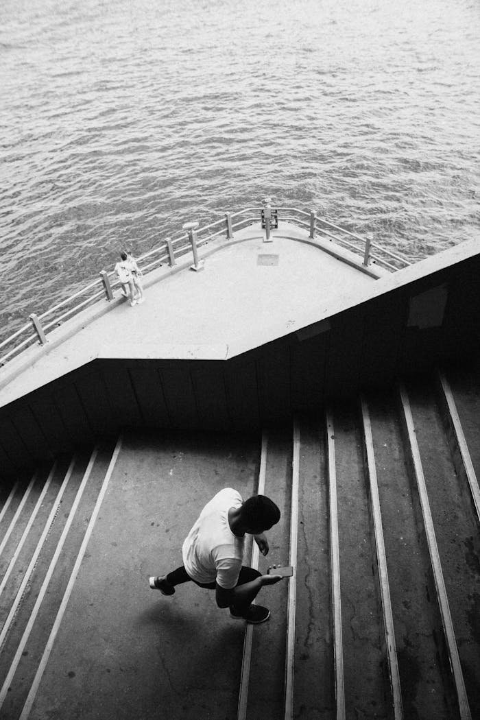 services-01 Dramatic black and white photo of a man on stairs by the sea in İstanbul.